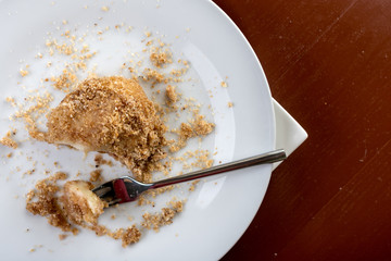 Flat lay above plum dumplings served on the plate on the brown dark wooden table