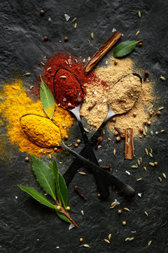 Colourful spice powder seasonings on dark background