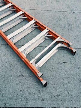 An orange ladder on concrete floor