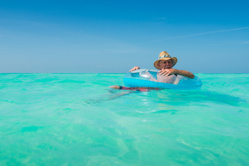 Senior Old Man Tourist at Sunny Turquoise White Sand All Inclusive Resort Beach In Caribbean