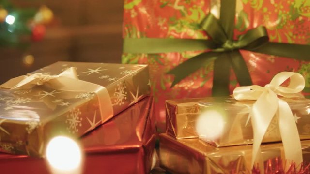 Close-up tracking shot of beautiful presents under the Christmas tree.
