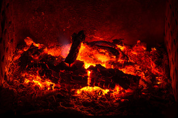 Embers with burned logs and ashes in a fireplace