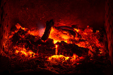 Embers with burned logs and ashes in a fireplace
