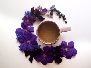 Obraz na płótnie Canvas violets on a white background in the form of a crescent around a cup of warm coffee