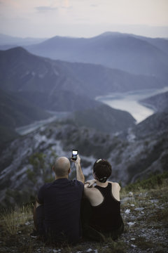 Couple enyoing at the mointain view and taking photos