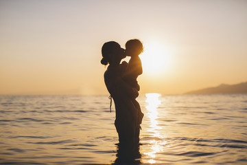 Fototapeta premium Mother holding her 1 year old son