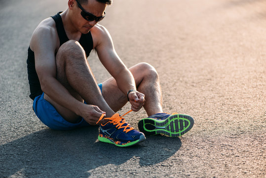 Chinese runner tying his shoelaces