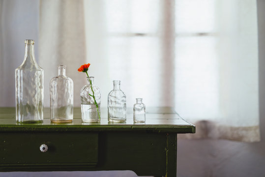 Glass bottles of decreasing size on table