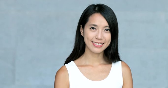 Asian young woman smile to camera over grey background