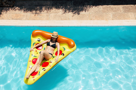 Woman On A Pizza Float In A Swimming Pool