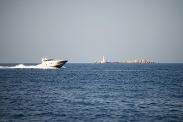 Small motor boat on sea, small island in background