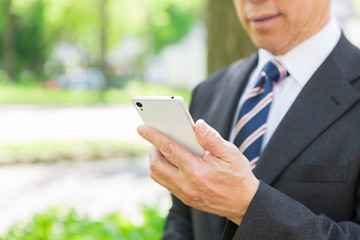 スマホを見るミドル男性　手元　ビジネス