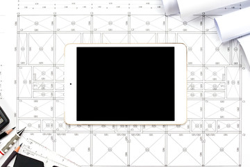 Digital tablet with drawings tools on abstract engineering drawings background.