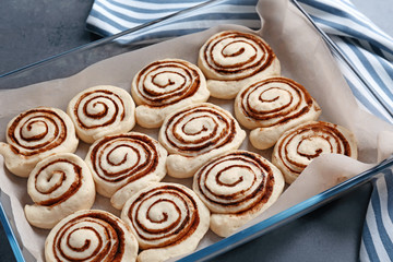 Raw cinnamon rolls in baking dish on table