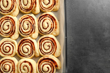 Raw cinnamon rolls in baking dish on table