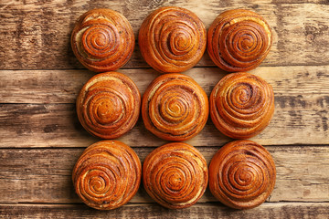 Sweet cinnamon rolls on wooden table