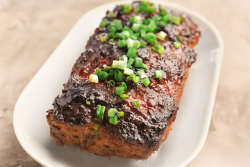 Plate with tasty baked turkey meatloaf on table