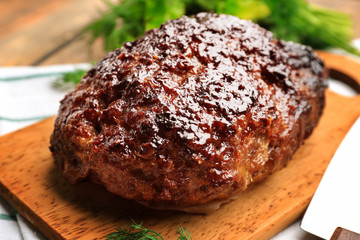 Tasty baked turkey meatloaf on wooden board, closeup
