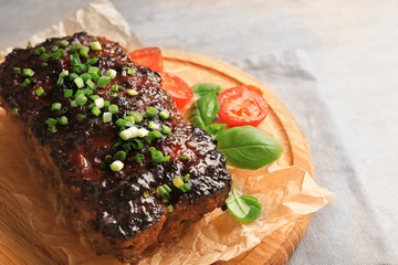 Tasty baked turkey meatloaf on wooden board