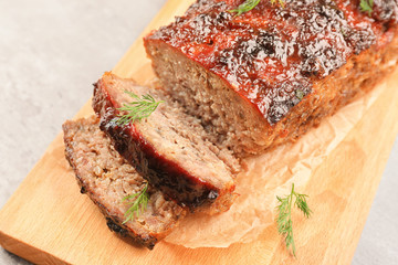 Tasty baked turkey meatloaf on wooden board