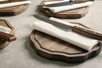 Knives with napkins and wooden boards on kitchen table. Cooking classes concept