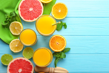 Composition with fresh juice and citrus fruits on color wooden background