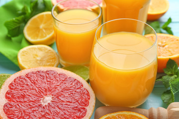 Composition with glasses of fresh juice and citrus fruits, closeup