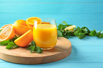 Composition with glass of fresh juice and citrus fruits on wooden table