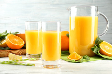 Composition with fresh juice and citrus fruits on wooden table