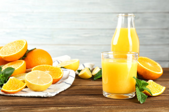 Composition with fresh juice and citrus fruits on wooden table