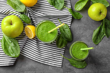 Tasty green smoothie and ingredients on table