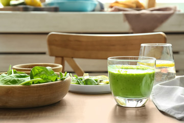 Composition with glass of spinach smoothie on wooden table
