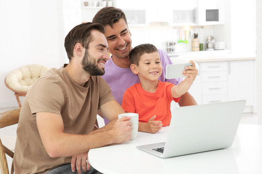 Male gay couple with foster son spending time together at home. Adoption concept