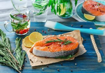 Fresh salmon steak with rosemary on wooden board