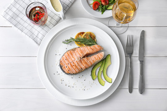 Grilled salmon steak with avocado and rosemary on plate