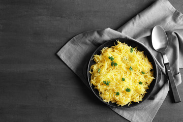 Frying pan with spaghetti squash on grey background