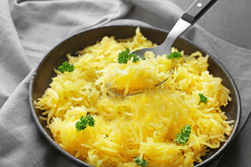 Frying pan with spaghetti squash on table