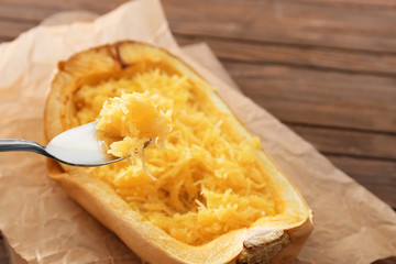 Spoon with tasty spaghetti squash on blurred background