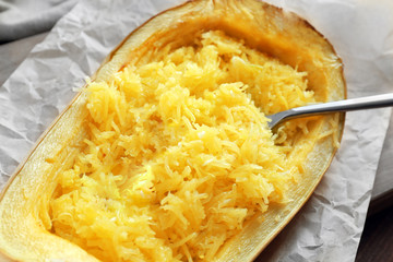 Tasty spaghetti squash with spoon on table