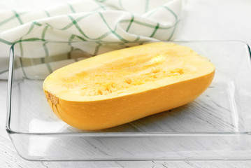Baking dish with fresh spaghetti squash on table
