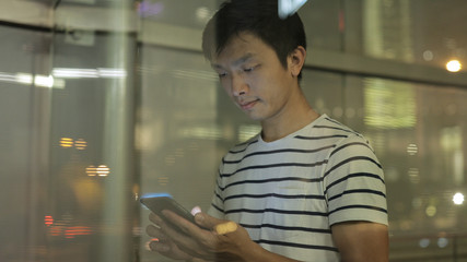 Young man using mobile phone at night