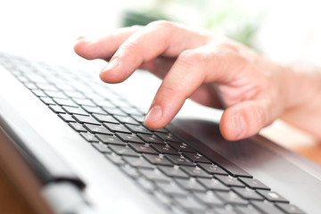 Hand on the laptop keyboard close-up