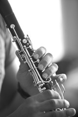 Hands of man playing the clarinet in black and white