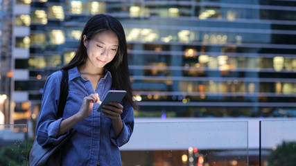 Woman working on cellphone at night