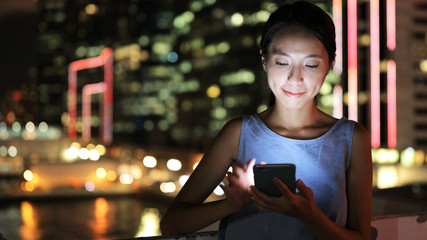 Asian woman using mobile phone at night