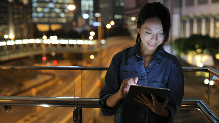 Woman using tablet computer at night