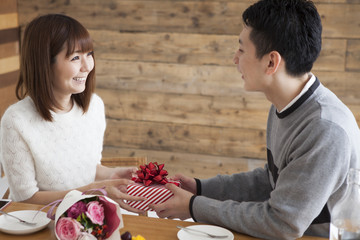 Man giving present and bouquet to woman