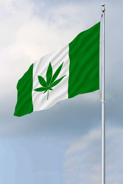 Green and white Canadian flag with a pot leaf waving in the wind on a flagpole