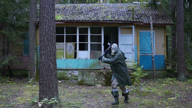 crazy stalker maniac in a gas mask attacks with an ax in his hands