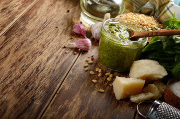 Pesto sauce ingredients and utensils on wood table